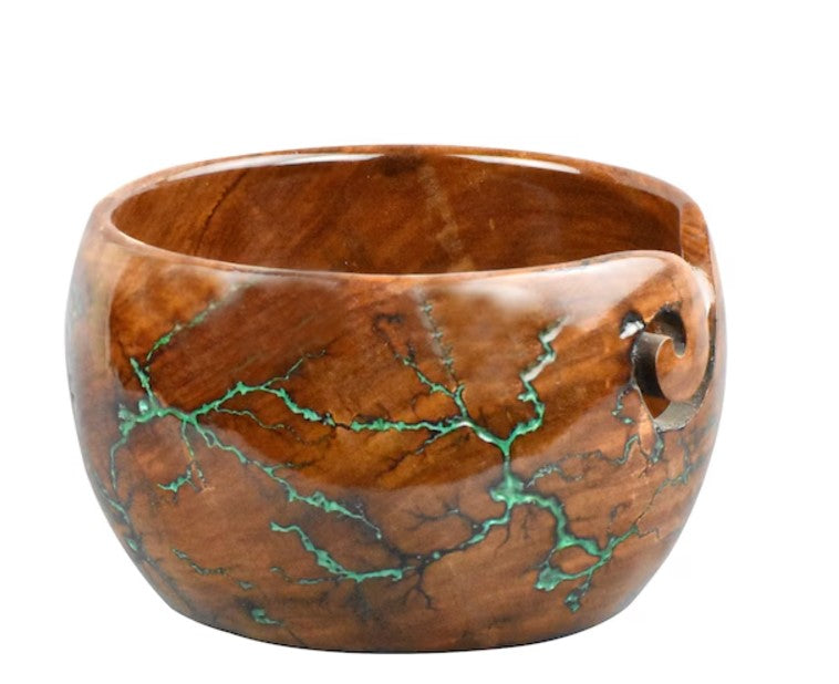 Brown bowl with green vein-like design and a thread-cutout curve.