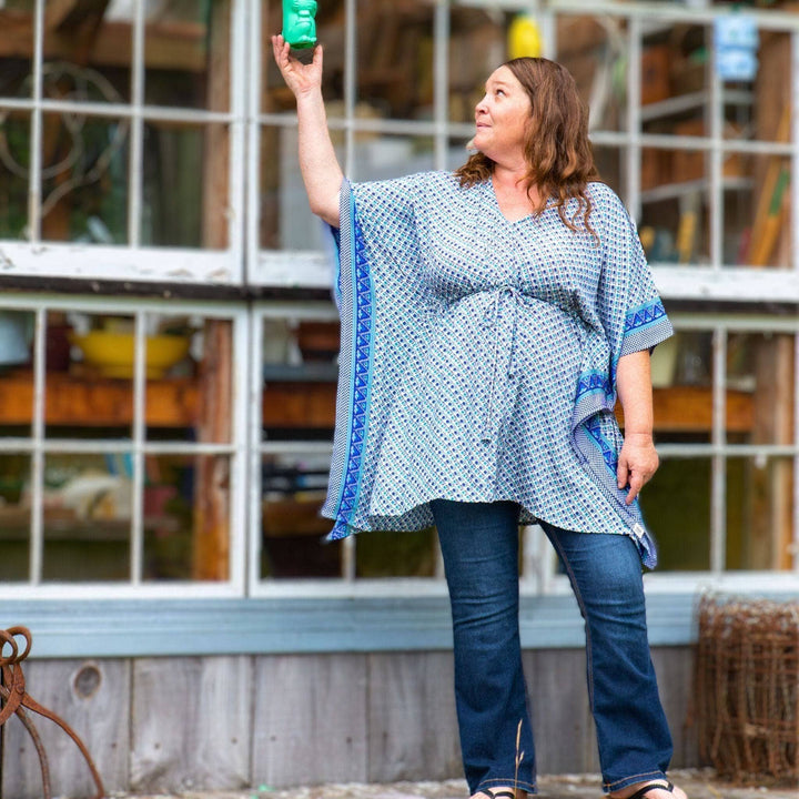 Woman standing in front of a house wearing a blue and white aanya short kaftan