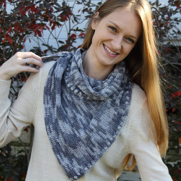 Woman wearing Andina Scarf in Date Night (grays) in front of fall foliage