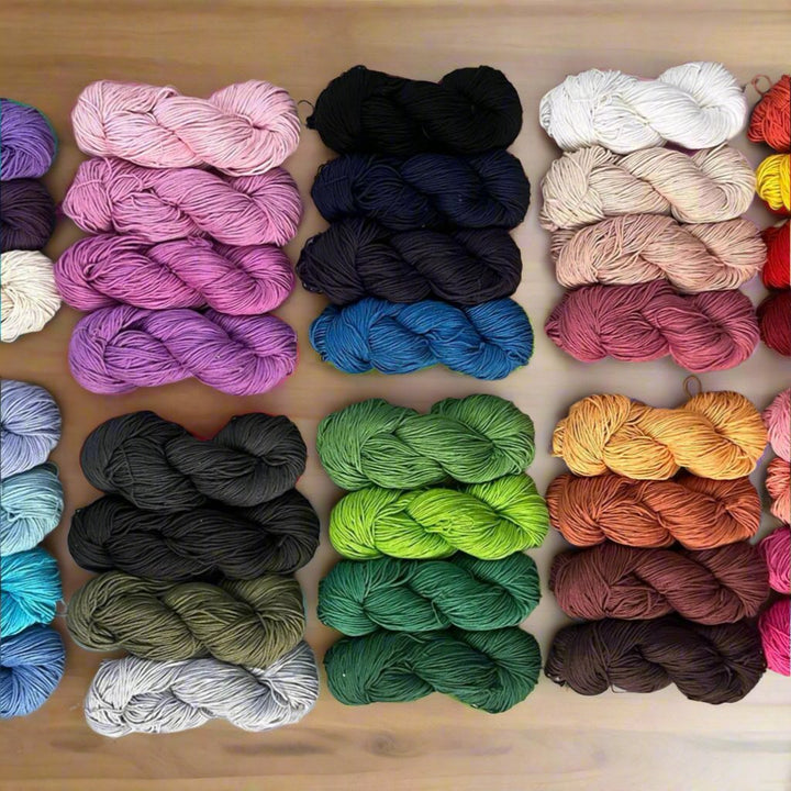 Various colorful yarn skeins arranged neatly on a wooden table.