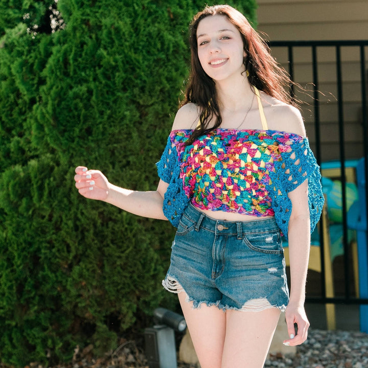 Model wearing astral crochet granny square top off the shoulder as a pool cover up.