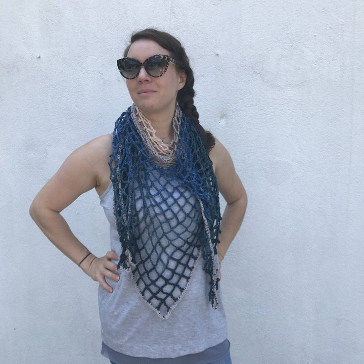 Woman wearing a Blue Jay Triangle Scarf and standing in front of a white wall