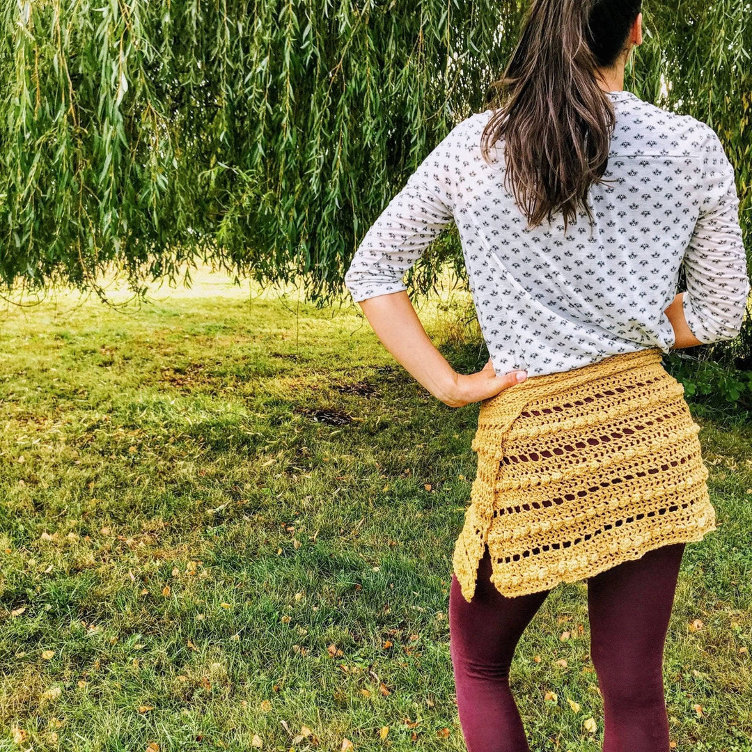 A woman wearing a beige crocheted skirt outside