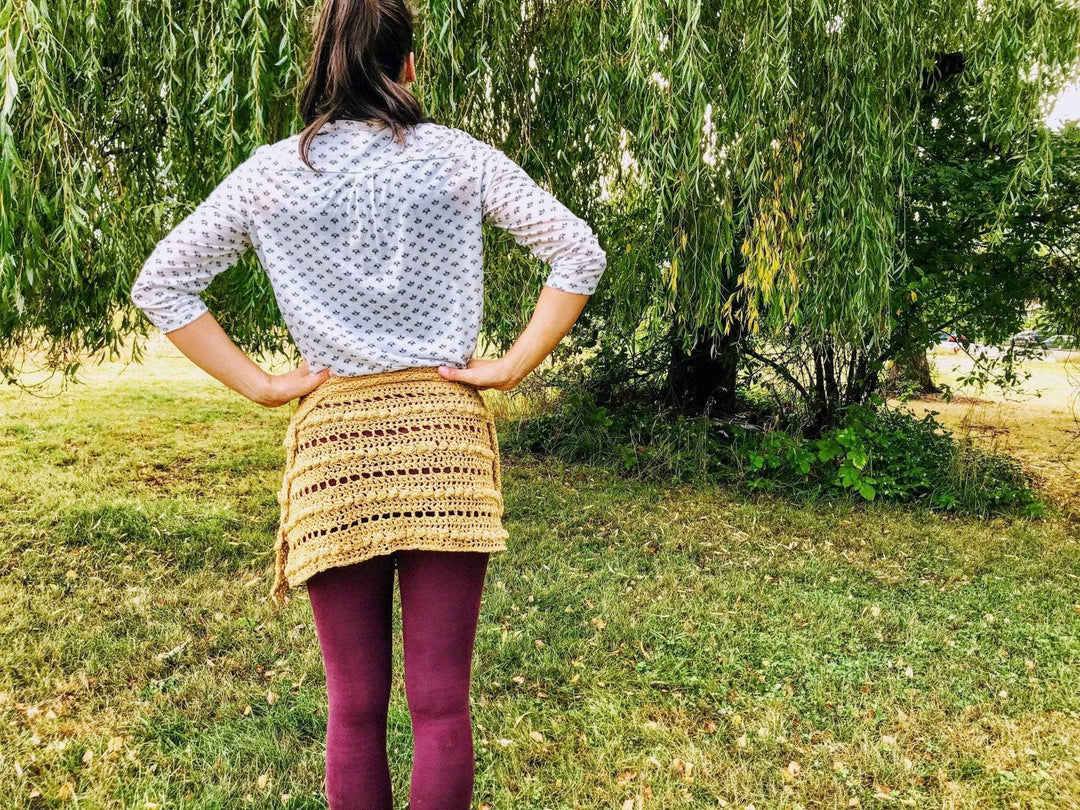 A woman wearing a beige crocheted skirt outside