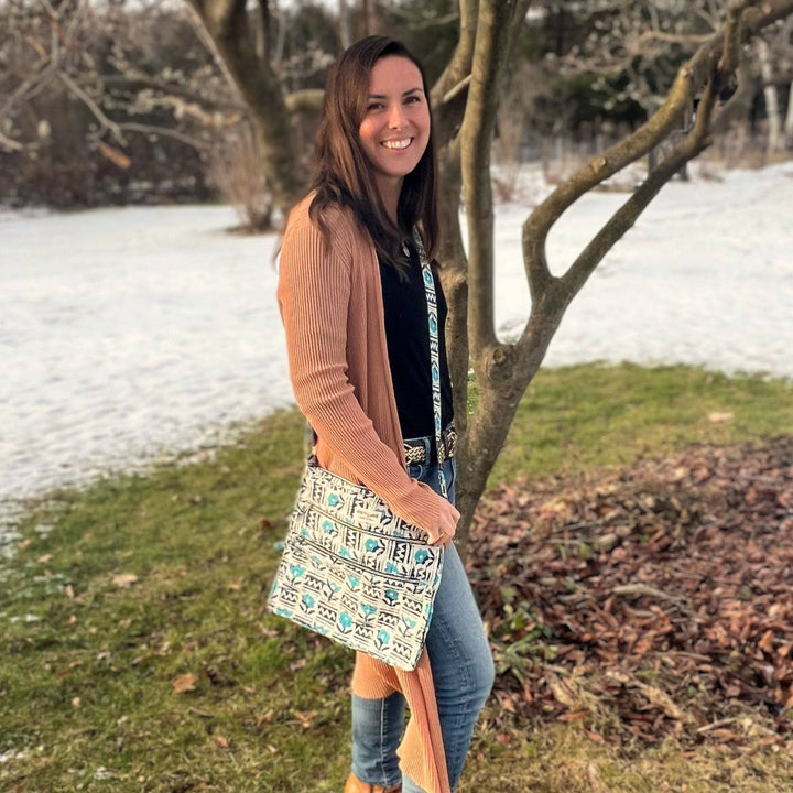 Woman standing in front of a tree wearing a blue and white bag