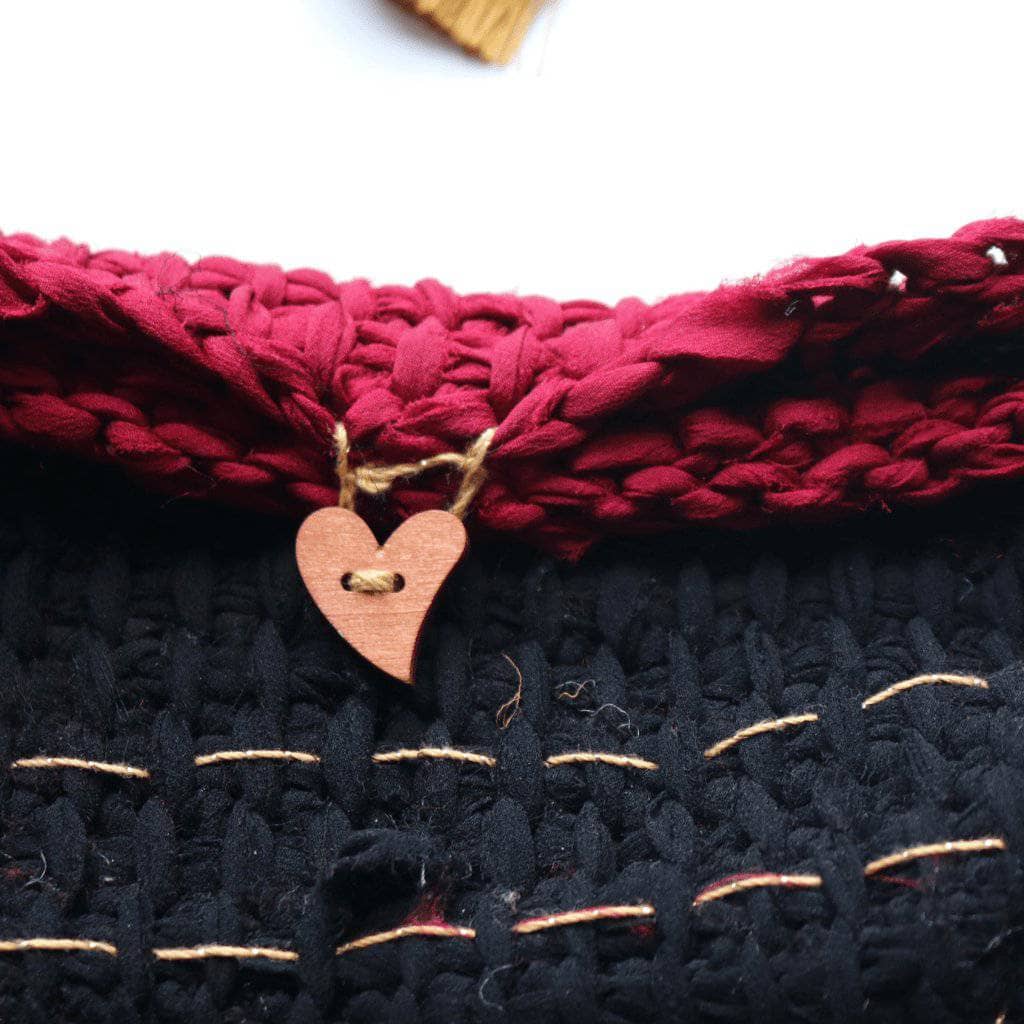 black, and pink clutch on a white background with a heart button