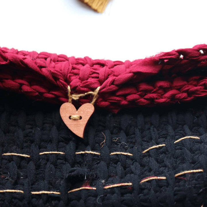 black, and pink clutch on a white background with a heart button