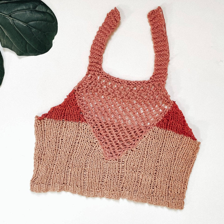 a pink bralette laying flat on a white background