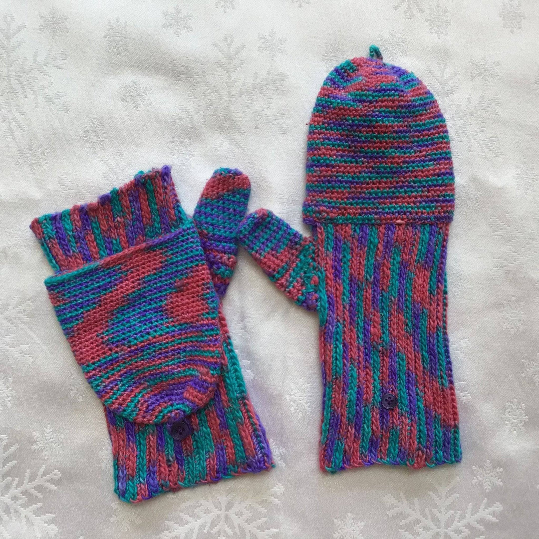 Blue, pink and purple mittens on a white background