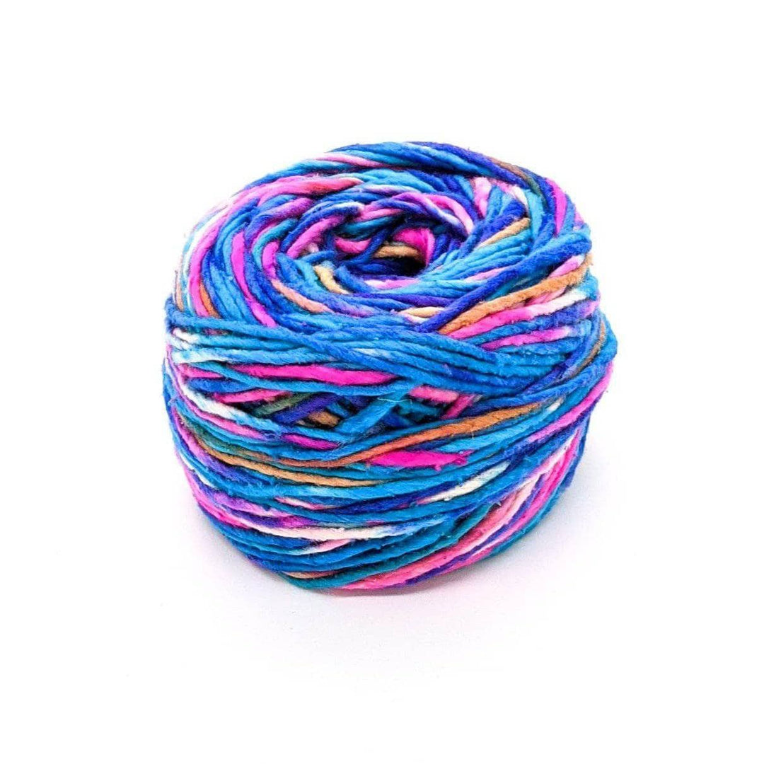 A cake of blue, pink, white, tan, and purple yarn on a white background