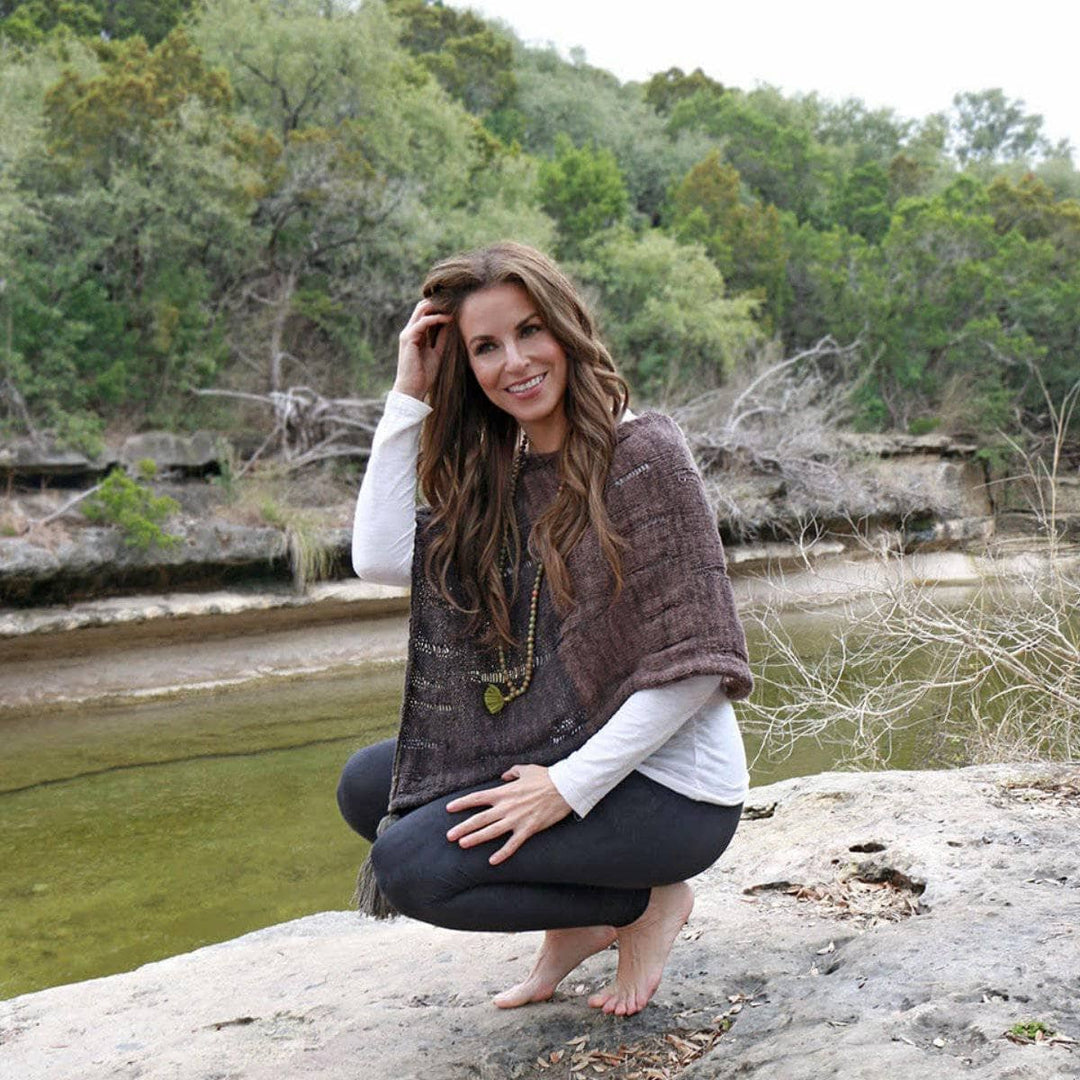 woman smiling wearing a brown poncho