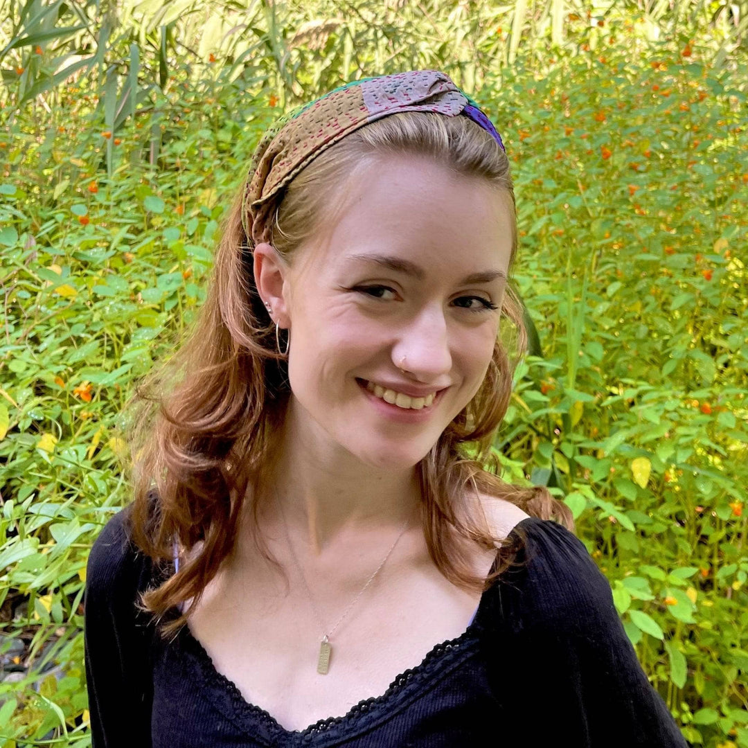 A girl standing outside with a neutral toned sari hair accessory in her hair.