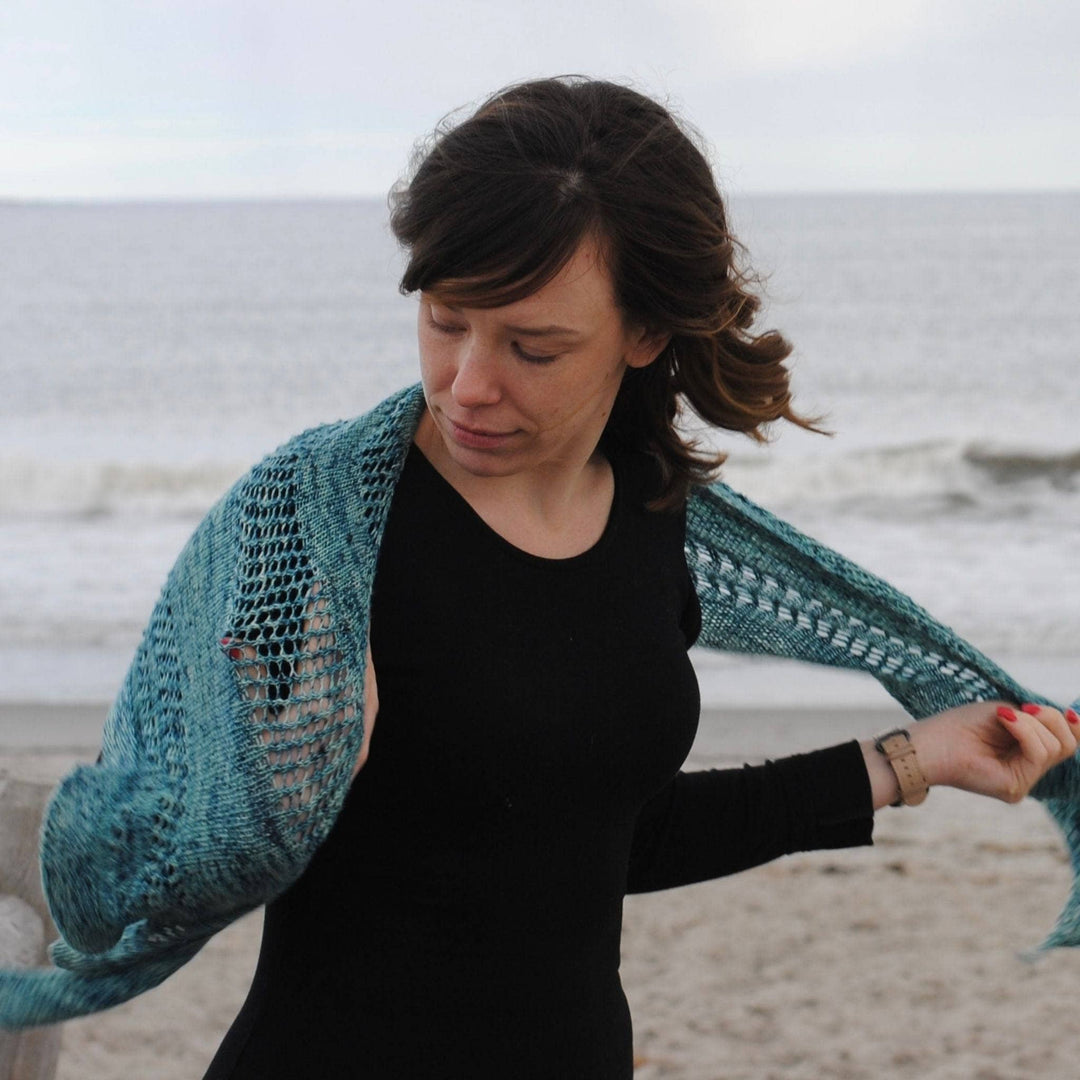 Model wearing emerald bay shawl with the ocean in the background.