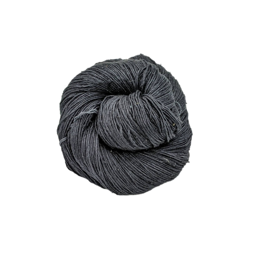 Lace weight silk yarn in color way black in front of white background.