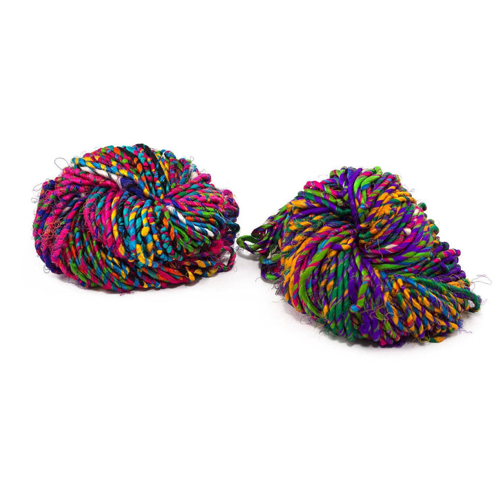 two cakes of multicolored yarn over a white background