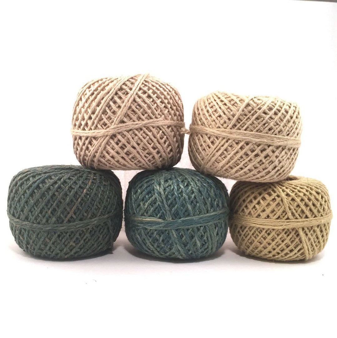 five yarn cakes of different colors over a white background