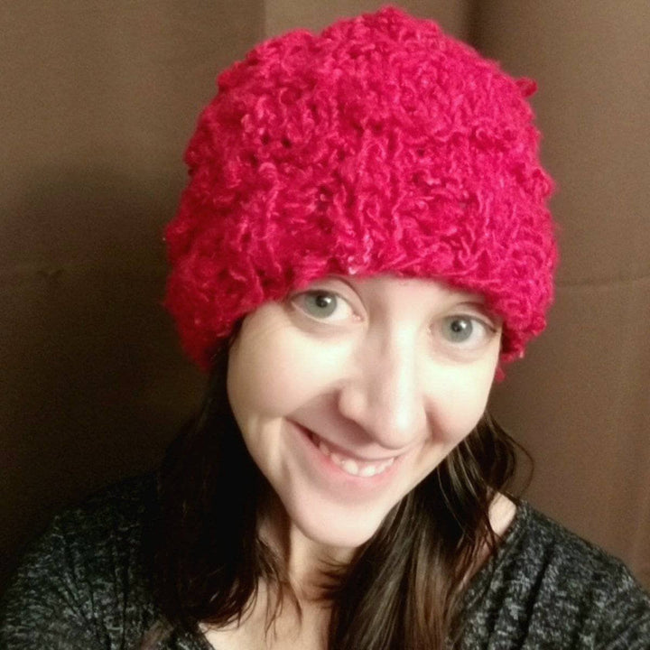 woman smiling and wearing a red Bananas Beanie