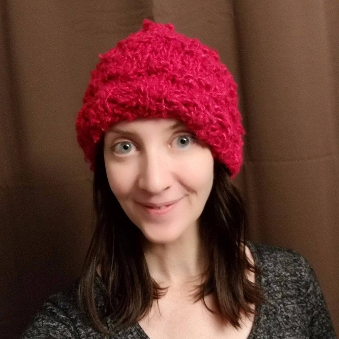 woman smiling and wearing a red Bananas Beanie