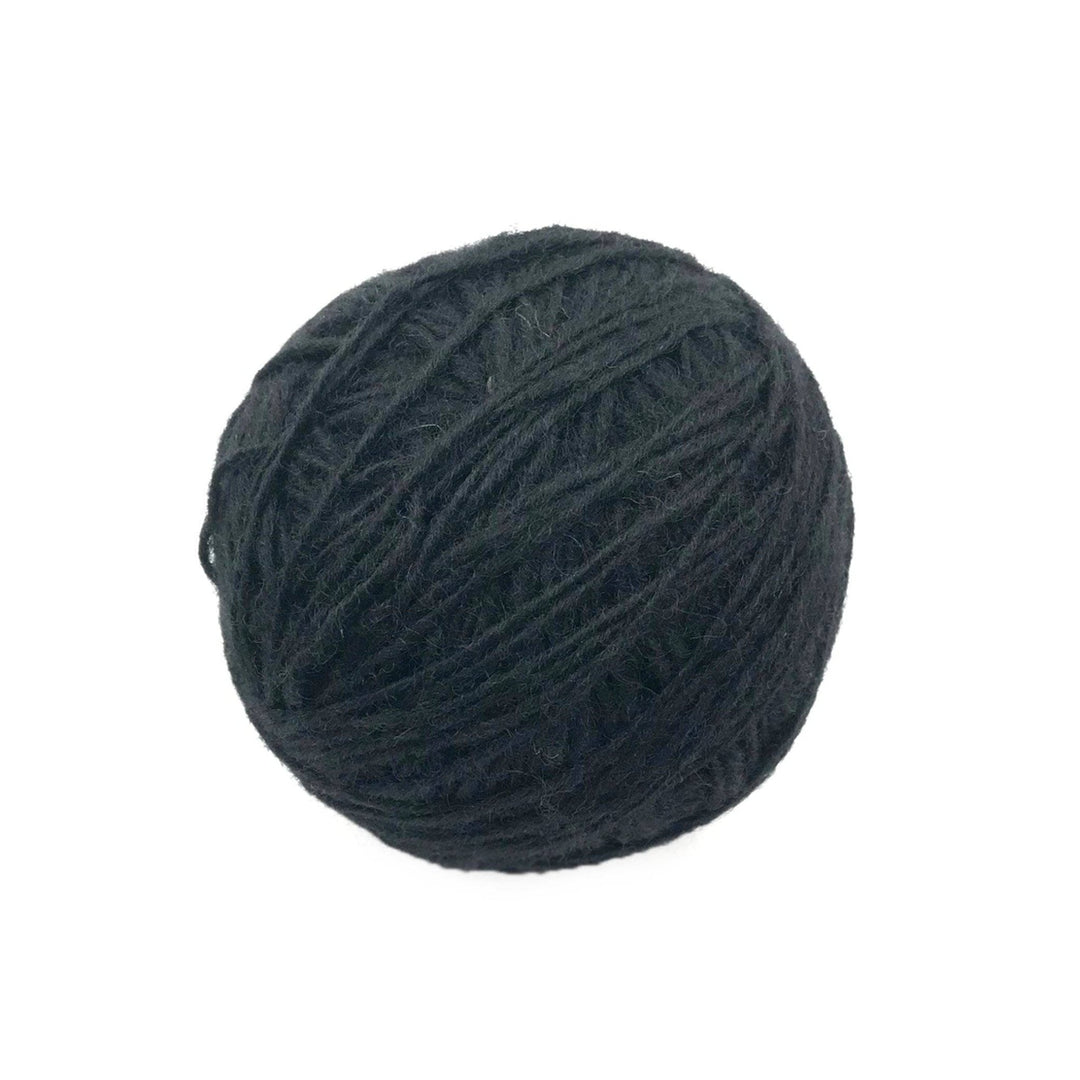 black yarn cake over a white background