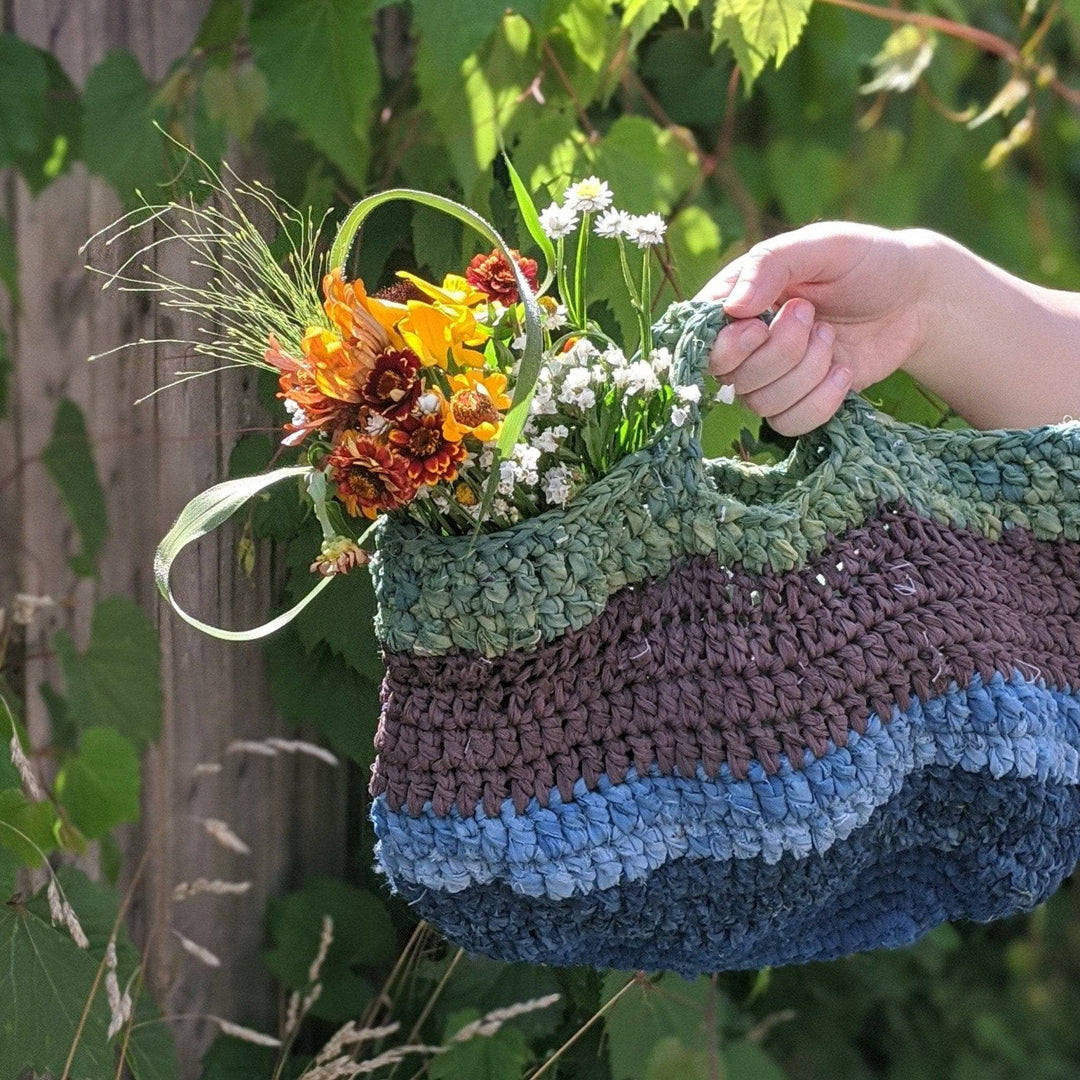 a cool toned colored bag being held outside