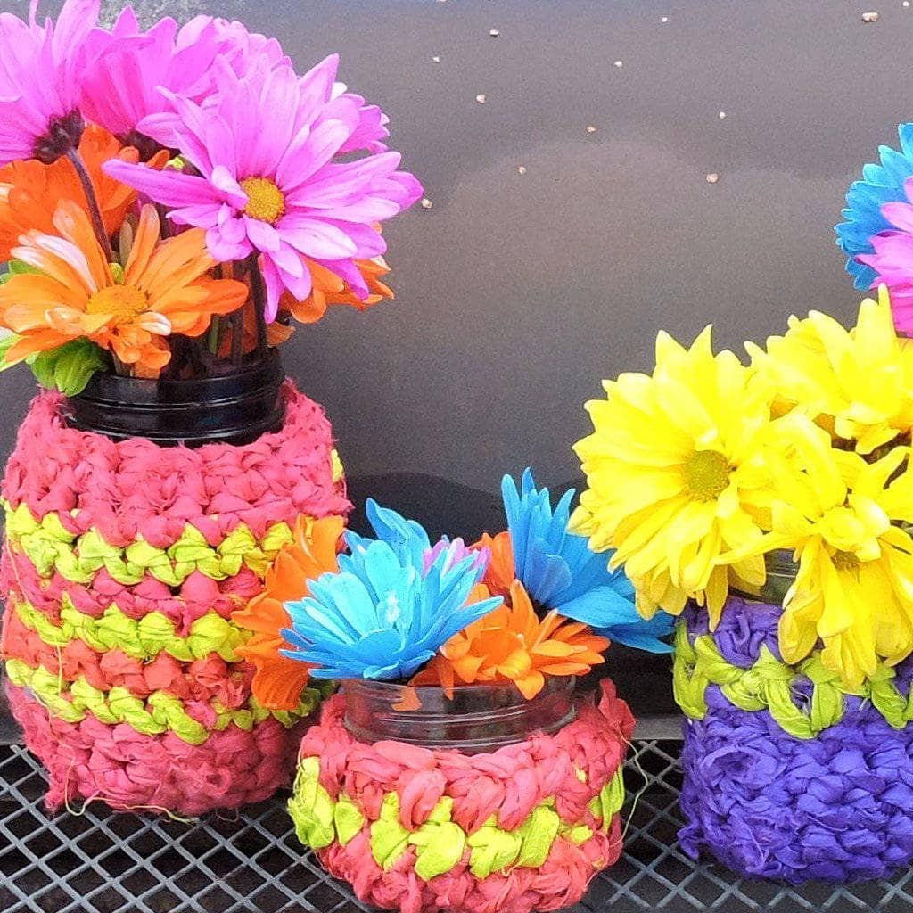 three Jar Cozies with flowers inside