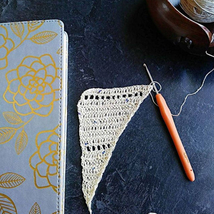 beige shawl over a black table and with a hook next to it