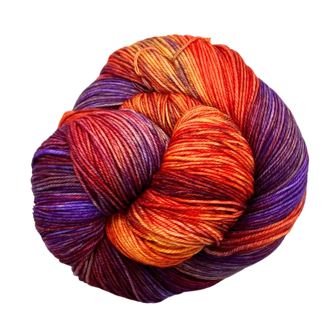 A vibrant skein of yarn blending fiery reds, oranges, and deep purples.