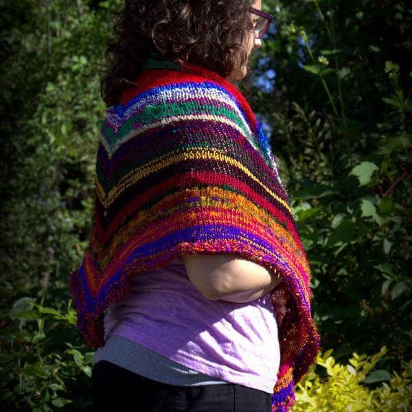 side of a woman wearing colorful red yellow blue and brown shawl