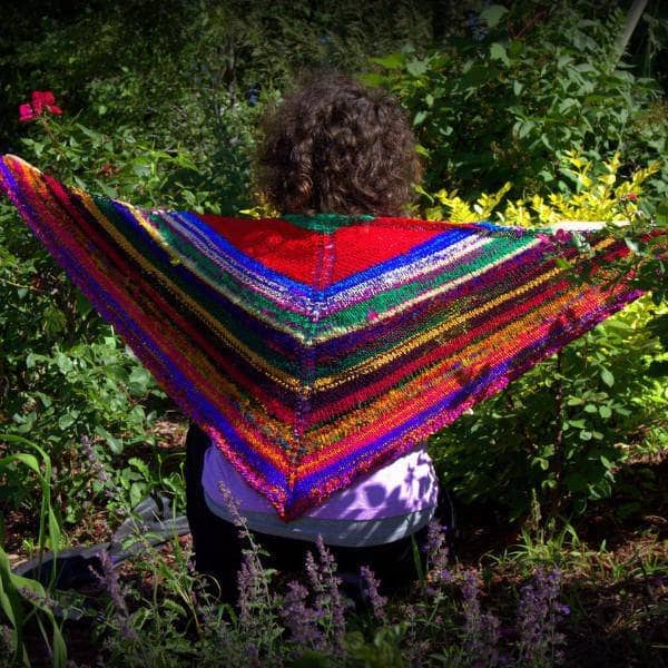 back of a woman wearing colorful red yellow blue and brown shawl