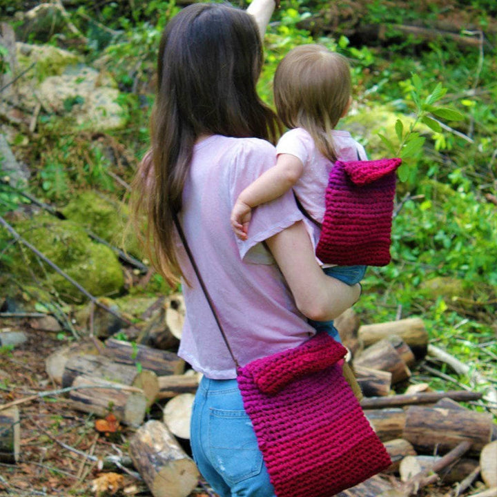 mom and child wearing a pink bag in a garden