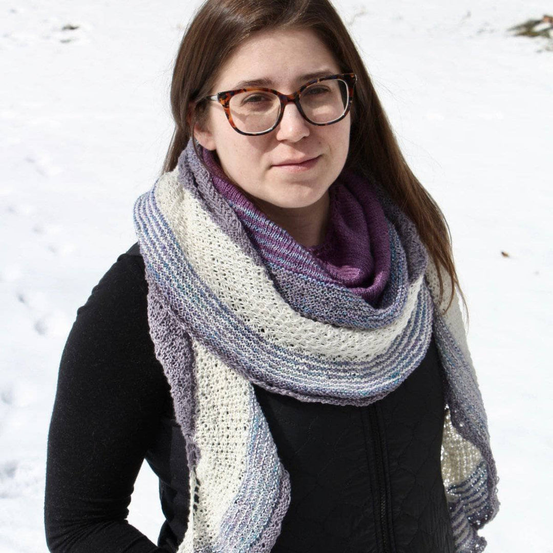 woman wearing a purple white and pink shawl with snow in the background