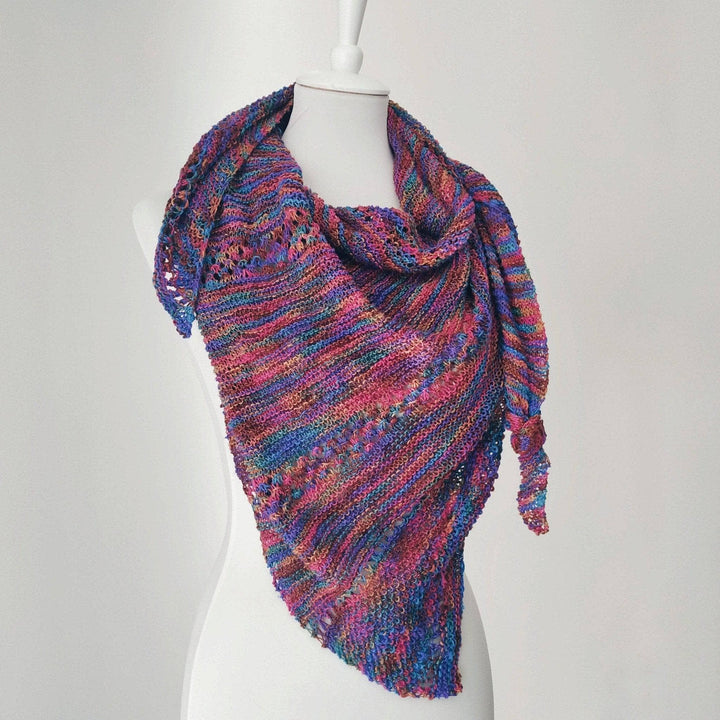 pink, purple , blue, brown knit shawl on a mannequin