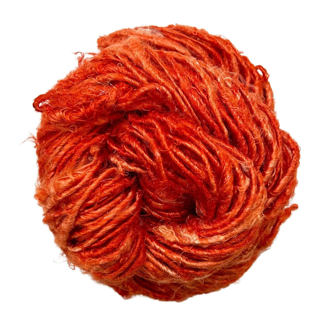 Close-up image of a skein of Plant Based Banana Fiber Yarn in a bright orange hue. The handspun yarn offers a soft and strong texture, perfect for eco-conscious knitting, crocheting, and mixed media projects.