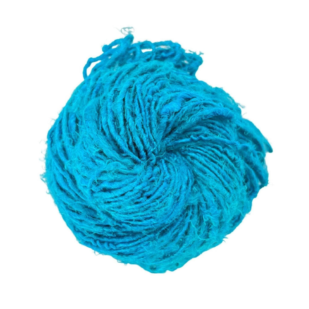 Close-up image of a skein of Plant Based Banana Fiber Yarn in bright turquoise. The handspun yarn showcases a soft, silk-like texture, making it perfect for eco-friendly knitting and crocheting projects.