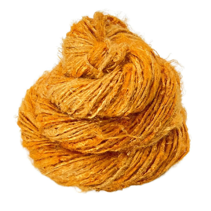 Close-up image of a skein of Plant Based Banana Fiber Yarn in a golden yellow hue. The handspun yarn features a soft and durable texture, perfect for creating vibrant and sustainable crafting projects.