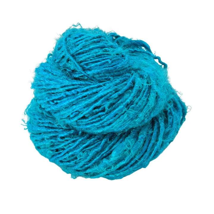 Close-up image of a skein of Plant Based Banana Fiber Yarn in bright turquoise. The handspun yarn offers a unique, soft texture, making it ideal for eco-conscious knitting and crocheting projects.