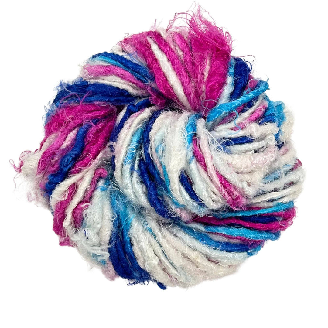 Close-up image of a skein of Plant Based Banana Fiber Yarn in a vibrant mix of pink, blue, and white. The handspun yarn displays a soft texture, perfect for various crafting projects with a sustainable twist.