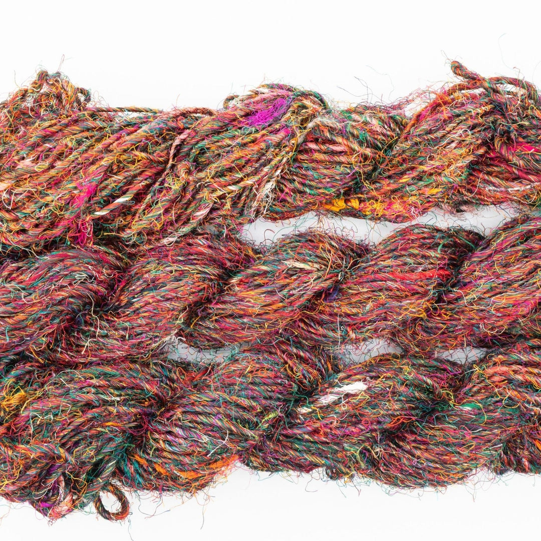 Close-up image of a skein of Plant Based Banana Fiber Yarn in a multicolored mix, showcasing the vibrant and unique textures of handspun banana fibers. Ideal for eco-friendly knitting, crocheting, and mixed media projects.