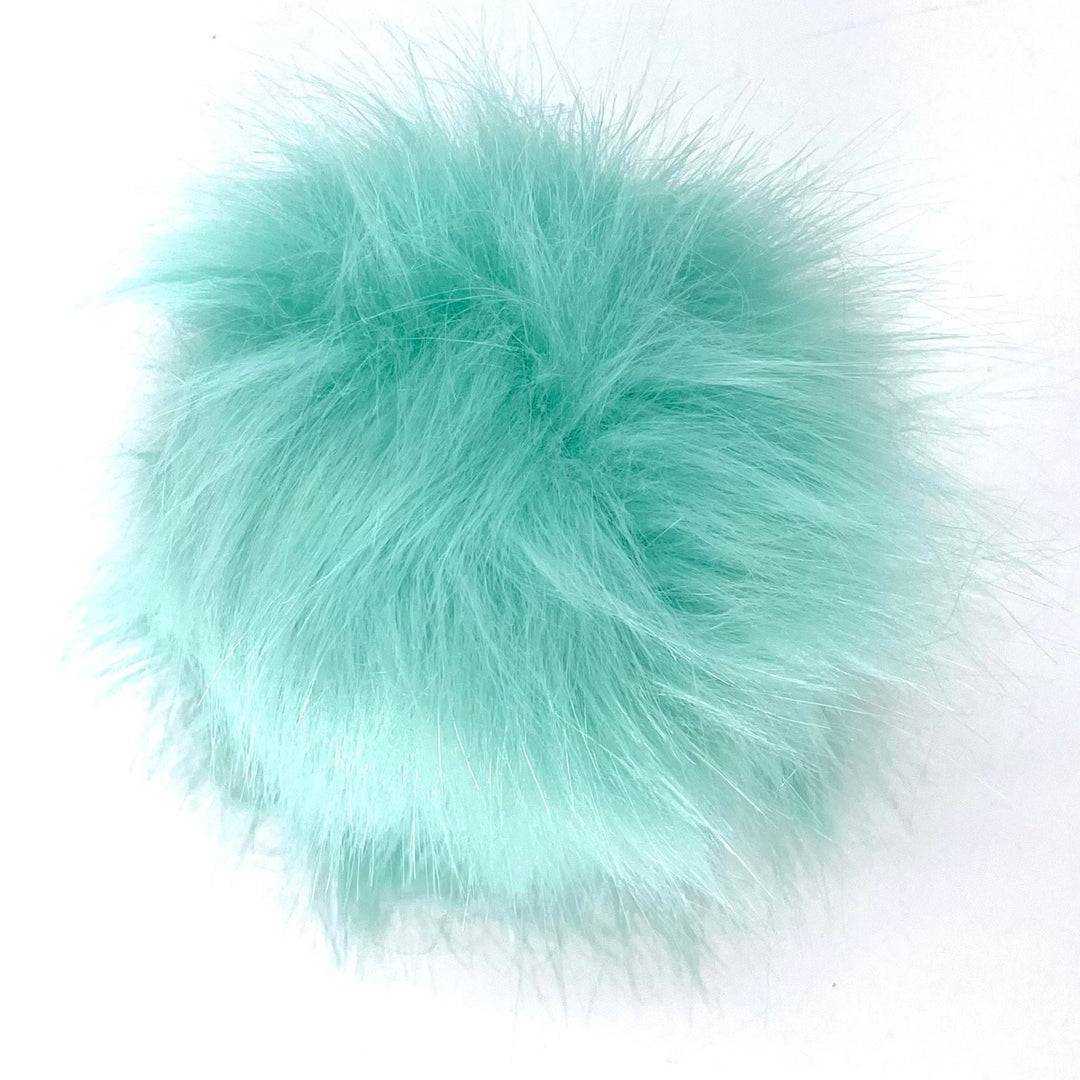 A plus 4.5 inch snap on pom pom in the colorway 'mint'