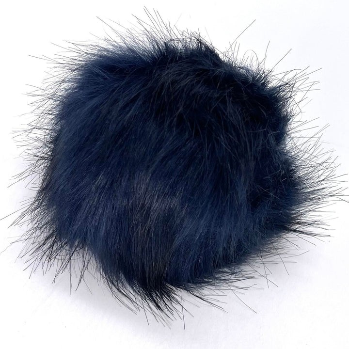 A plus 4.5 inch snap on pom pom in the colorway 'navy'