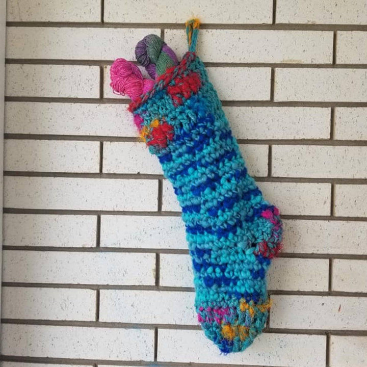 blue holiday Stocking in a floor with pumpkins on the side