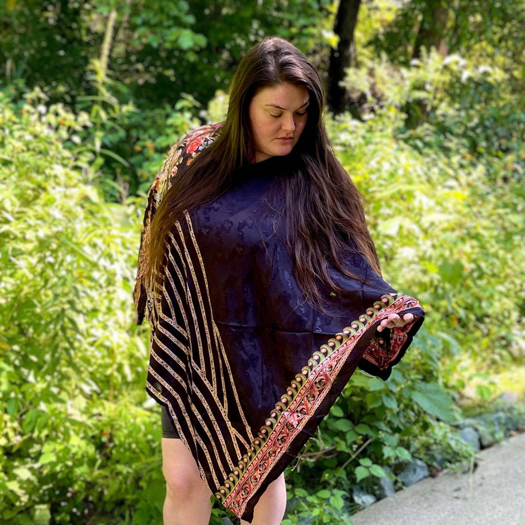 A woman on the streel with a nature background wearing organic clothing.