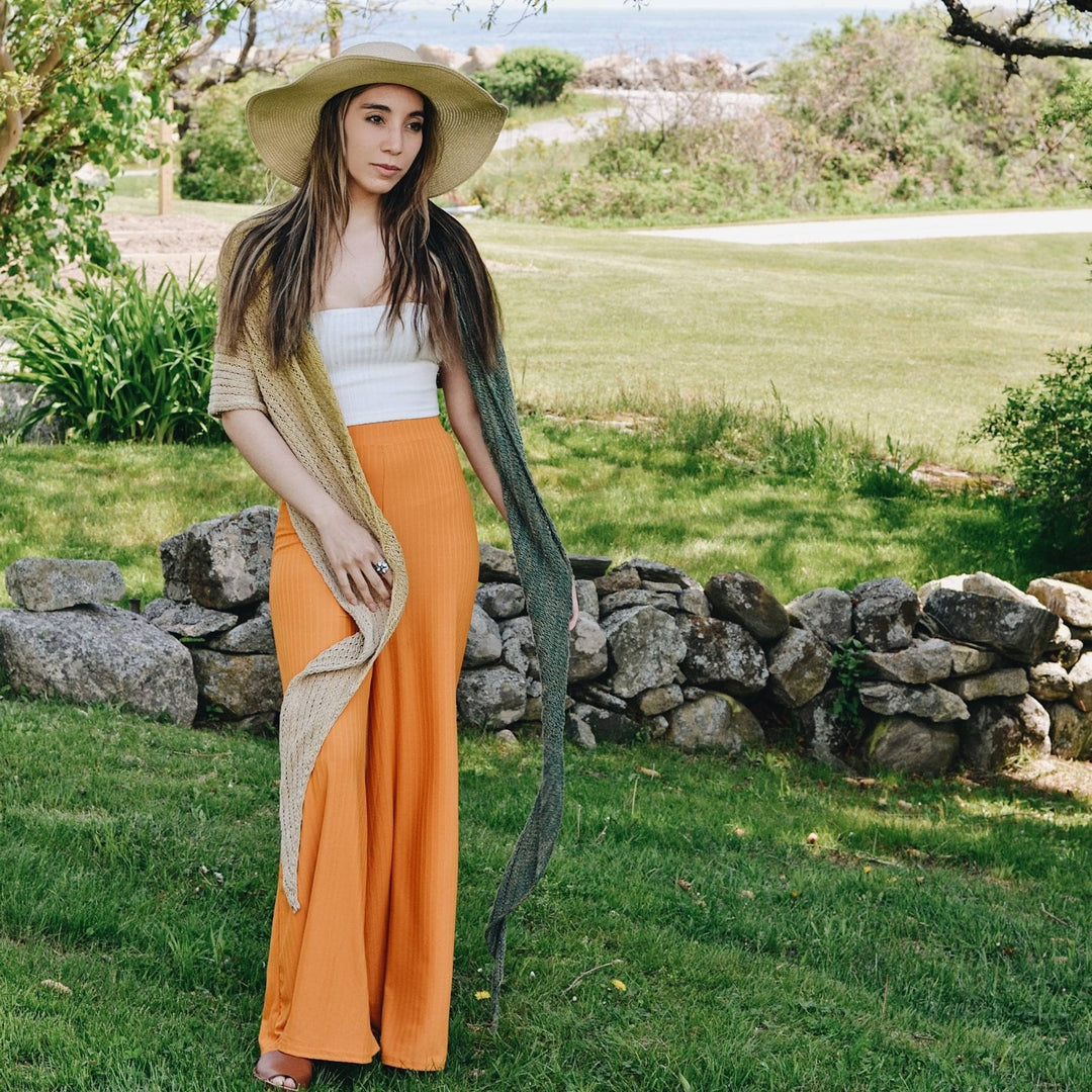 bias knit silk shawl pattern being worn by model with greenery in the background.