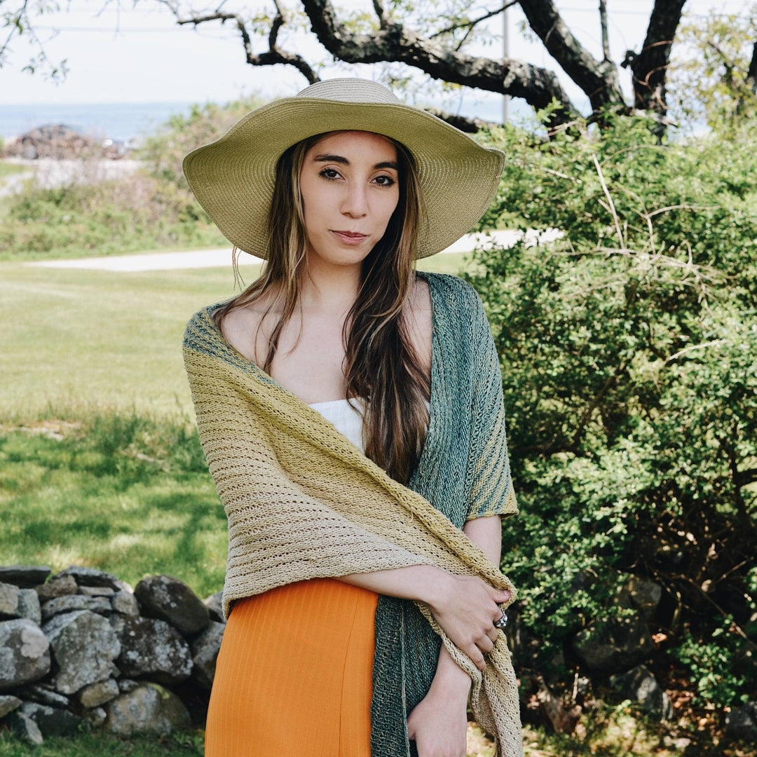 model wearing herbal dyed recycled silk shawl with greenery in the background.