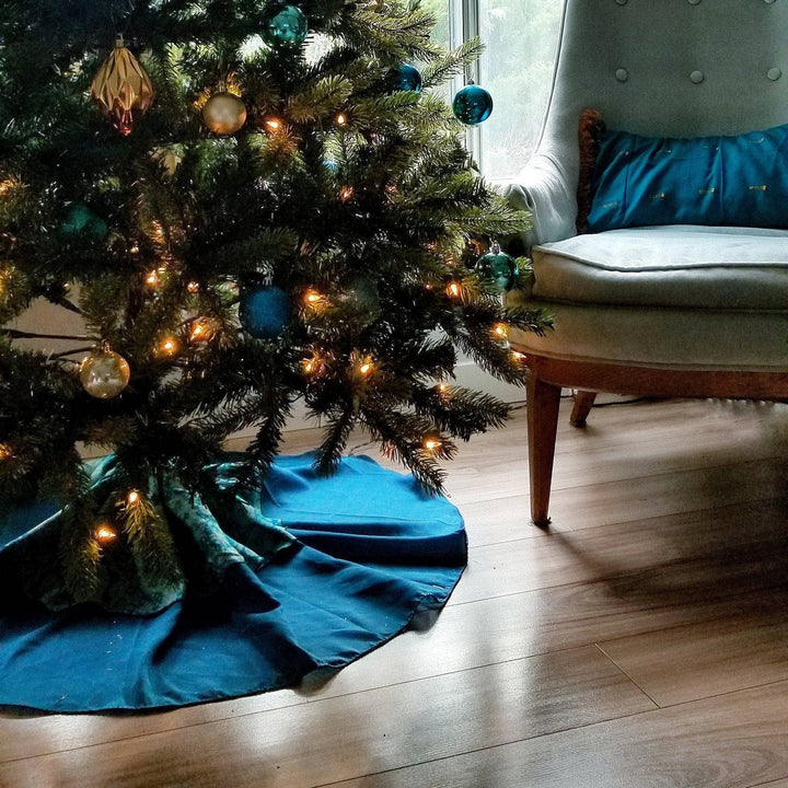 Christmas tree with a blue tree skirt around it