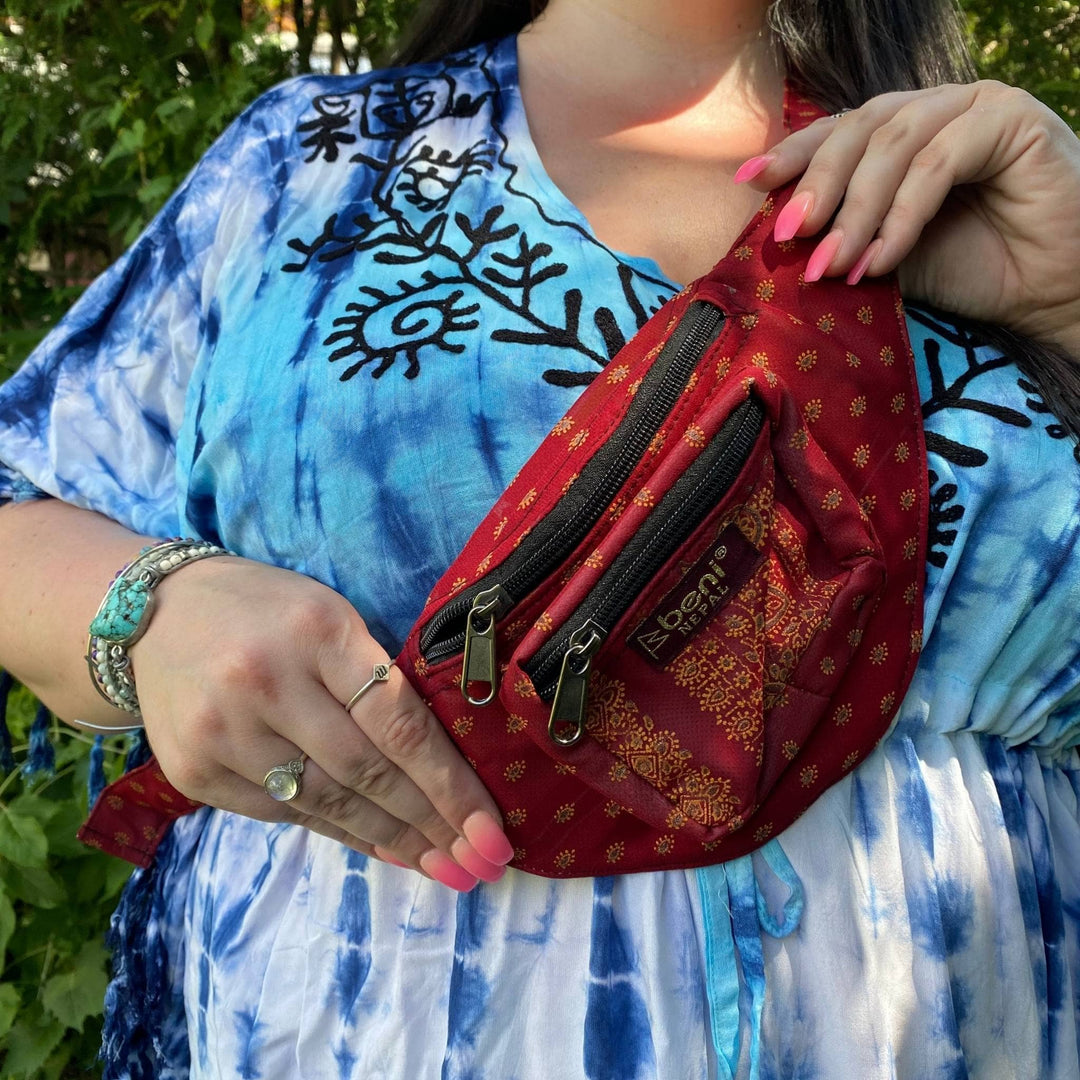 Closeup of model wearing a red sari silk fanny pack across their chest. 