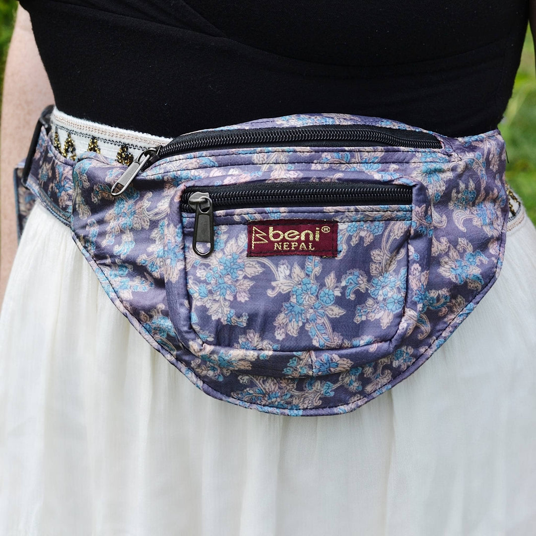 Purple floral sari silk fanny pack around a model's waist. 