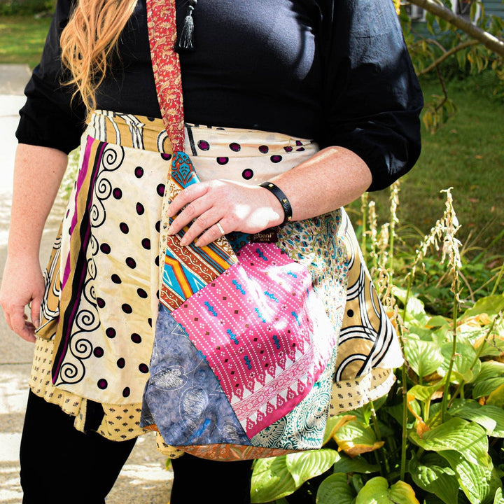 A woman in a garden wearing a Sari Wrap Skirt with the Sari Purse worn across her body.