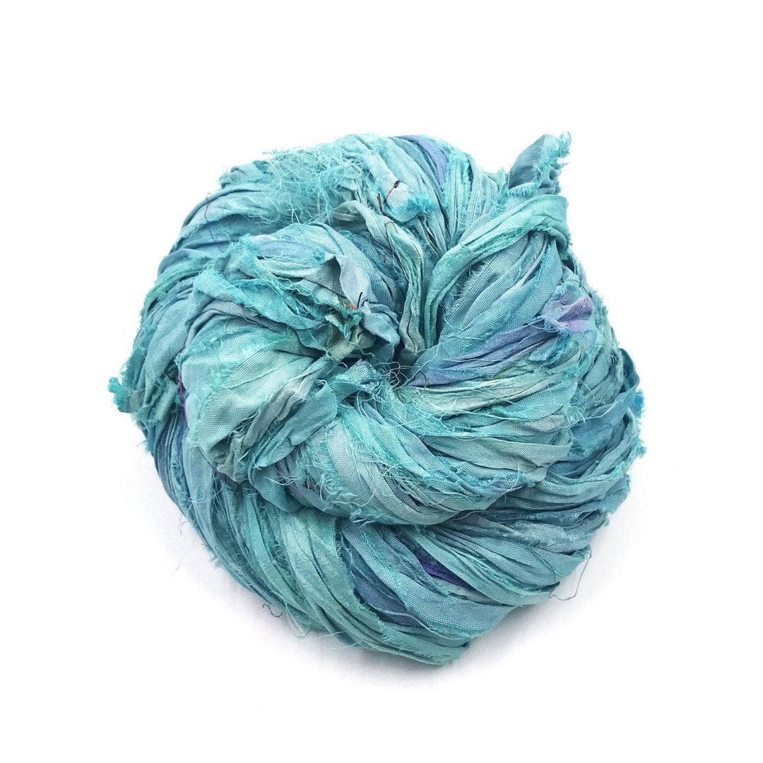 A skein of light blue ribbon yarn on a white background