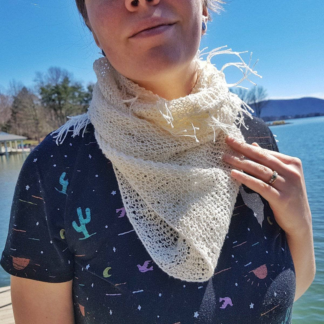 Women wearing a white cowl outside by a lake 